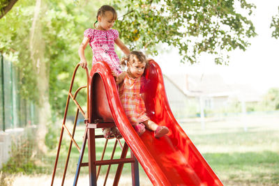 Happy girl playing on slide at playground