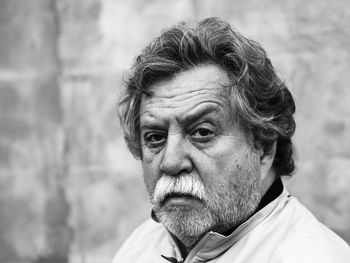 Close-up of sad thoughtful senior man against wall