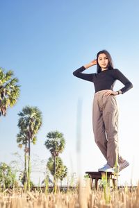 Low angle view of woman standing against clear sky