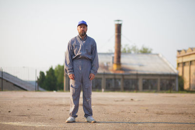 Portrait of man standing against built structure