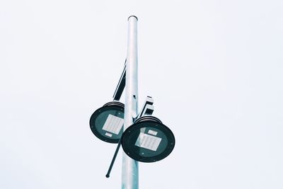 Low angle view of telephone pole against white background