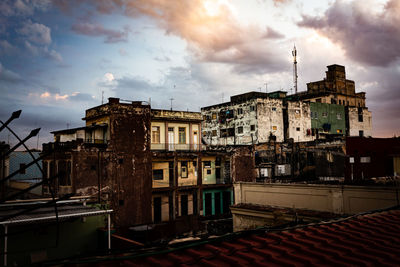 Old buildings in town against sky at sunset
