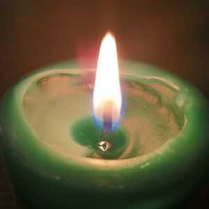 Close-up of lit candle in darkroom