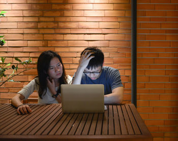 Couple using laptop at table