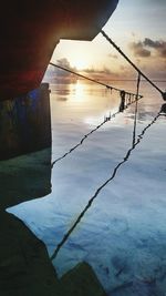 Scenic view of swimming pool by lake against sky during sunset