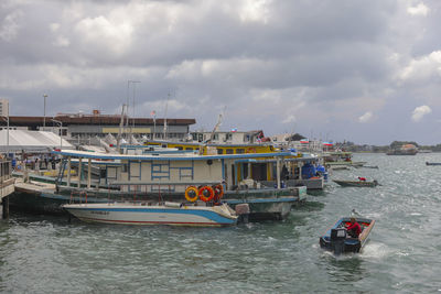 Boats moored in sea against sky