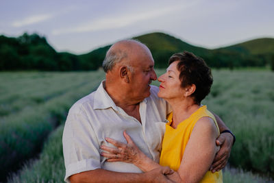 Side view of senior couple kissing on field