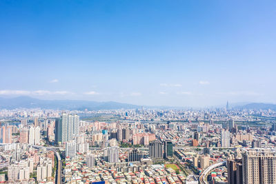 High angle view of modern buildings against blue sky