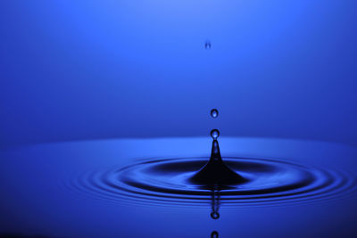 Close-up of water drop against blue background