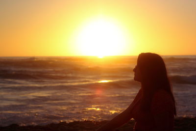 Silhouette woman standing at sunset