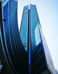 Low angle view of skyscrapers against blue sky