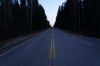 Empty road along trees