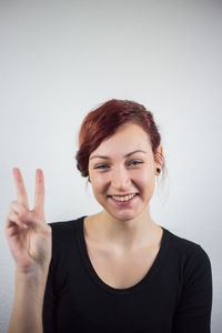 Portrait of smiling young woman against white background