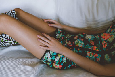 Midsection of woman lying down on sofa