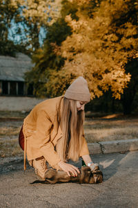 Pet love. volunteer woman plays with homeless puppies in the autumn park. authentic moments of joy