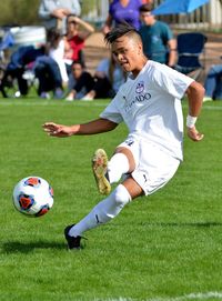 Woman playing soccer ball on grass