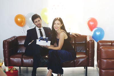 Young couple holding balloons