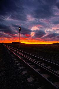 Railroad tracks against sky during sunset