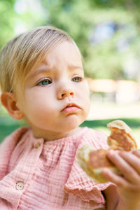 Cute girl eating food sitting outdoors