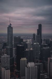 Skyscrapers in city against cloudy sky