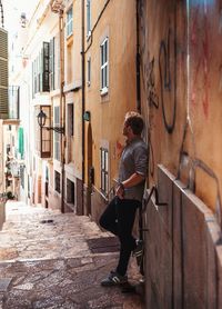 Man standing on staircase amidst buildings