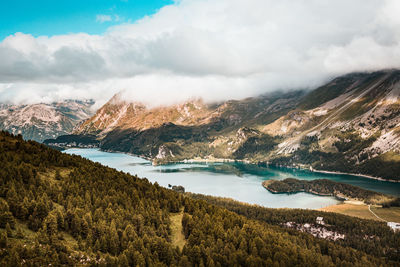 Scenic view of lake by mountains against sky