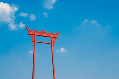 Low angle view of red tower against blue sky