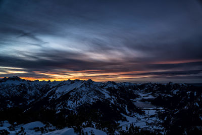 Scenic view of snowcapped mountains against sky during sunset