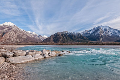 Scenic view of lake by mountains against sky