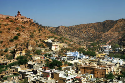 High angle view of townscape and mountains against clear sky