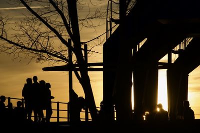 Silhouette people standing against sky during sunset