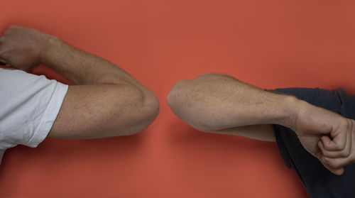 Close-up of hands against red wall