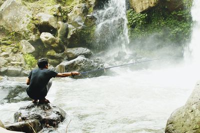 Man surfing on rock