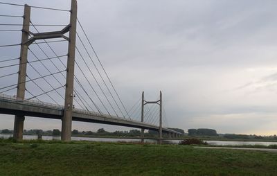 View of suspension bridge against cloudy sky