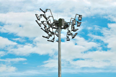 Low angle view of floodlights against sky