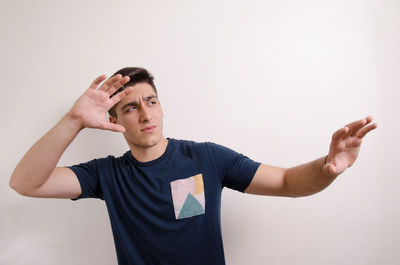 Portrait of young man standing against white background