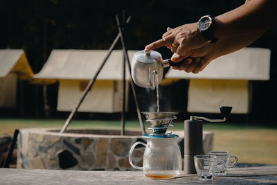 Drip coffee man pouring hot water on coffee ground with filter.