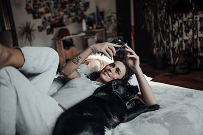 Midsection of woman lying down on bed at home