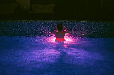 Rear view of woman swimming in pool