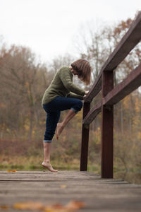 Side view of woman standing on footpath