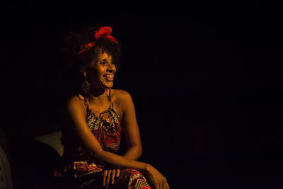 Young woman standing against black background