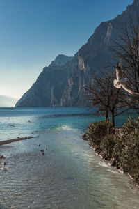 Scenic view of sea and mountains against clear sky