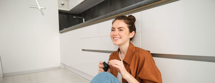 Portrait of young businesswoman standing against wall