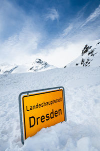 Text on snow covered mountain against sky