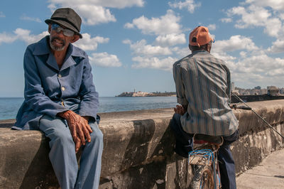 Man wearing hat against sea against sky