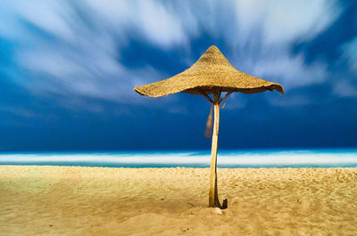 Umbrella on beach against sky