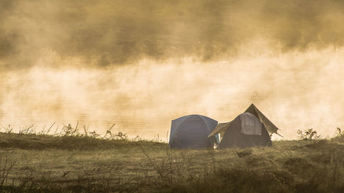 Tents on field during foggy weather