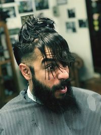 Man making face while wearing clip in hair at salon