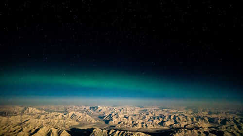 Aerial view of snowcapped landscape against star field at night