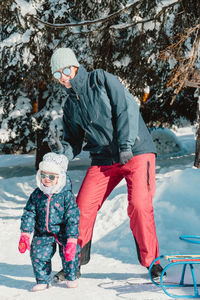 Mother and daughter on snow covered mountain